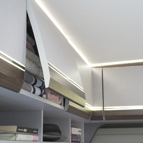 OBERSCHRÄNKE MIT VIEL PLATZ | Die Reling in den Oberschränken sichert große und schwere Ladung zusätzlich, die optisch durchlaufenden LED-Streifen in den Klappen sorgen für noch mehr Licht.
